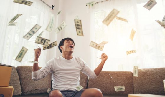 Happy man with cash dollars flying in home office, Rich from bus